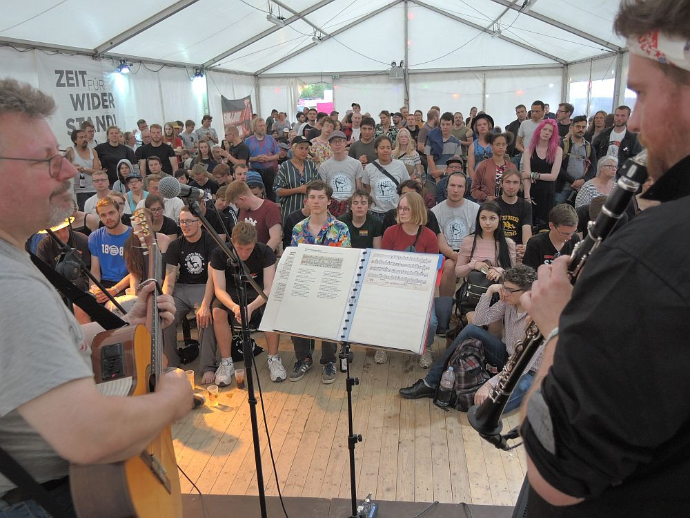 Achim Bigus an der Gitarre, ein volles Zelt und stundenlang gemeinsam Lieder aus 150 Jahren Arbeiterbewegung singen, das gehört zum Festival, wie Cuba Libre und Hamburger Fünfkampf.