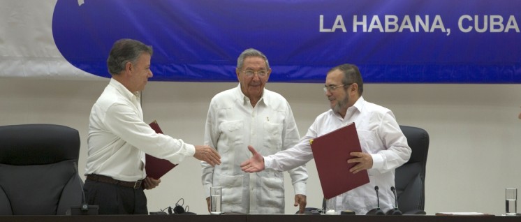 Kolumbiens Präsident Juan Manuel Santos (links) und der Vertreter der FARC, Timoleón Jiménez (rechts), reichen sich die Hand. In der Mitte Kubas Präsident, Raúl Castro. (Foto: Ladyrene Pérez / Cubadebate)