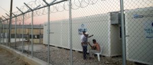 Flüchtlinge im Lager auf Chios, Griechenland (Foto: [Url=https://commons.wikimedia.org/wiki/File:Inhabitants_of_Suda_refugee_camp_seen_through_barbed_wire_fence_surrounding_it,_Chios,_Grece,_Aegean_Sea._29_September,_2016.jpg]Mstyslav Chernov/Wikimedia Commons[/url])