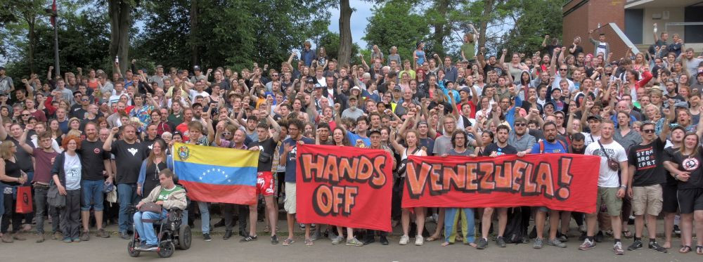 Fäuste ballen, Hände weg: Nach der Rede Carolus Wimmers, Internationaler Sekretär der Kommunistischen Partei Venezuelas, zeigten die Teilnehmer mit diesem Foto ihre Solidarität mit dem venezolanischen Volk, das sich gegen Angriffe aus den USA verteidigt.
