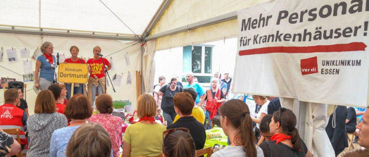 Grüße an die Streikenden: Am Donnerstag vergangener Woche halten VertreterInnen von Betrieben und Organisationen Grußworte im Streikzelt vor der Essener Uniklinik – hier von einem Dortmunder Krankenhaus. (Foto: Dave Kittel)