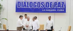 Kuba ist Vermittler in den Friedensverhandlungen – und Bezugspunkt für eine neue Gesellschaft: Raúl Castro beim Handschlag zwischen dem kolumbianischen Präsidenten Santos und Timoleón Jiménez, dem Oberkommandierenden der FARC. (Foto: Yenny Muñoa / CubaMINREX)