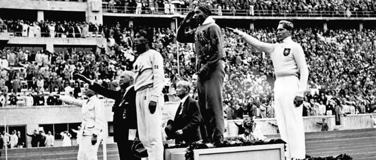 Olympische Spiele 1936 in Berlin, Siegerehrung im Weitsprung. Der Sieger Owens (USA) in der Bildmitte wäre nach der Naziideologie ein „Untermensch“. (Foto: Bundesarchiv, Bild 183-G00630 / Unknown? / CC-BY-SA 3.0)