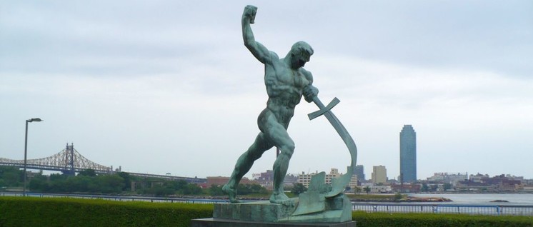 „Schwerter zu Pflugscharen“ soll wieder in das Programm der IG Metall aufgenommen werden. Im Bild die Statue vor dem Hauptquartier der Vereinten Nationen in New York City, 1957 geschaffen von dem sowjetischen Bildhauer Jewgeni Wiktorowitsch Wutschetitsch. (Foto: [url=https://commons.wikimedia.org/wiki/File:Garden_at_the_United_Nations_Headquarters,_New_York_City_-_panoramio.jpg] 	Colin W / Wikimedia Commons[/url])