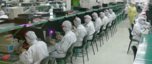 Der Chef schaut über die Schulter: In der Foxconn-Fabrik in Shenzhen produzieren überwiegend gering qualifizierte Arbeiter für Konzerne wie Apple. (Foto: [url=https://commons.wikimedia.org/wiki/File:Electronics_factory_in_Shenzhen.jpg]Steve Jurvetson[/url])