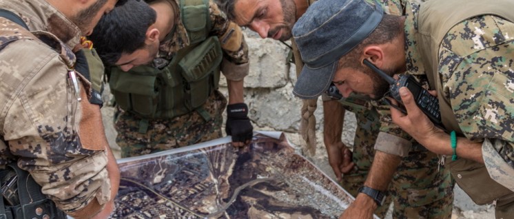 SDF-und YPG-Kämpfer studieren eine Karte, die sie vom IS erobert haben. (Foto: Willi Effenberger)