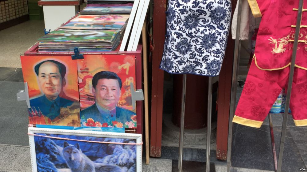Je nach Blickrichtung: Mal ist Mao zu sehen, mal Xi. Hologramm an einem Marktstand in der VR China.