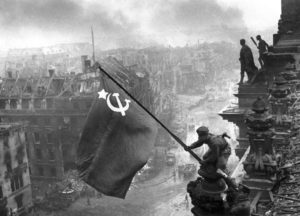 Soldat der Roten Armee hisst Sowjetflagge auf dem Reichstagsgebäude.