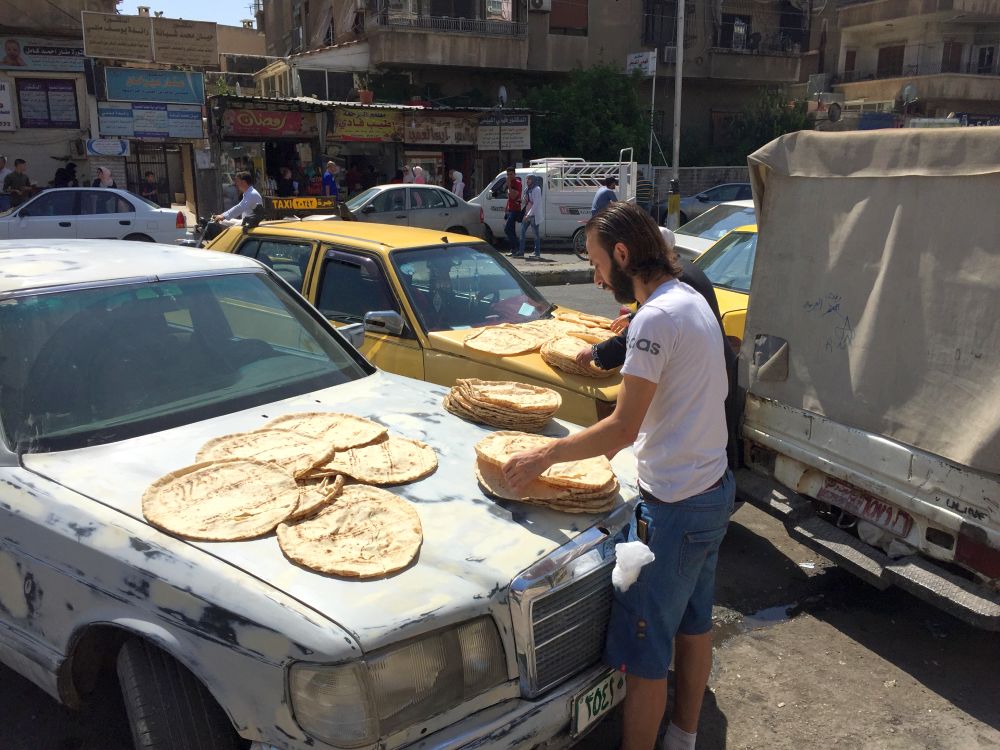 Direkt aus dem Ofen. Wenn das Brot verkauft wird ist es noch heiss wird zum Abkuehlen ausgelegt - Damaskus im September 2020 - Reportage, Syrien - Im Bild