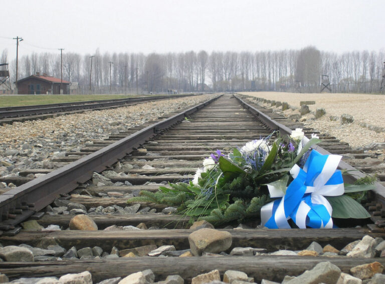 KZ Auschwitz Birkenau Bahngleise der Entladerampe Blumen zum Gedenken - FIR unterstützt berechtigte Forderungen nach Kompensation faschistischer Verbrechen - Fédération Internationale des Résistants - Fédération Internationale des Résistants