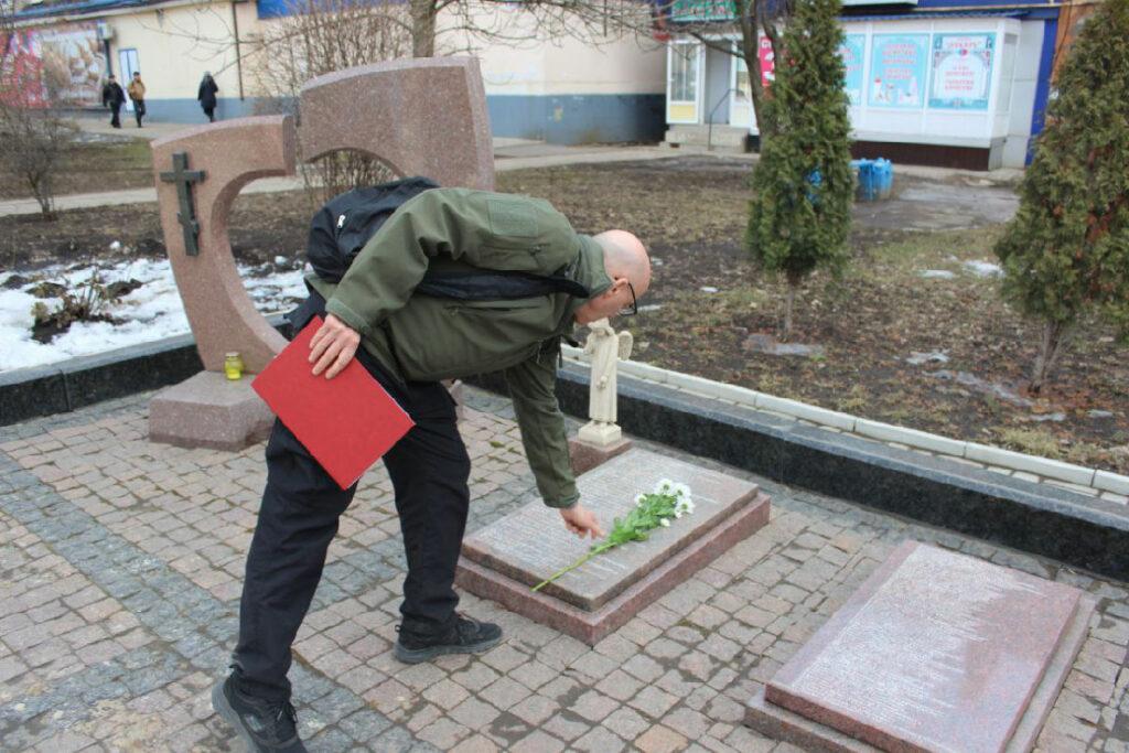 David Cacchione legt Blumen nieder in einer Gedenkstätte in Gorlowka für zivile Opfer des Krieges in der Ukraine seit 2014.