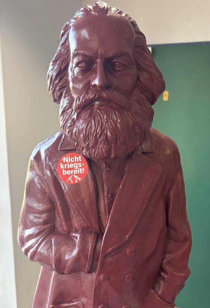 Im Foyer des Parteitags positioniert sich Karl Marx eindeutig gegen Krieg. Foto: UZ
