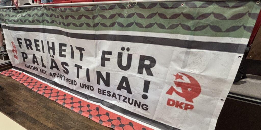 „Keine Zusammenarbeit mit Apartheidstaaten!“ - - Klare Positionierung für ein freies Palästina im Rücken des Parteitags. Foto: UZ