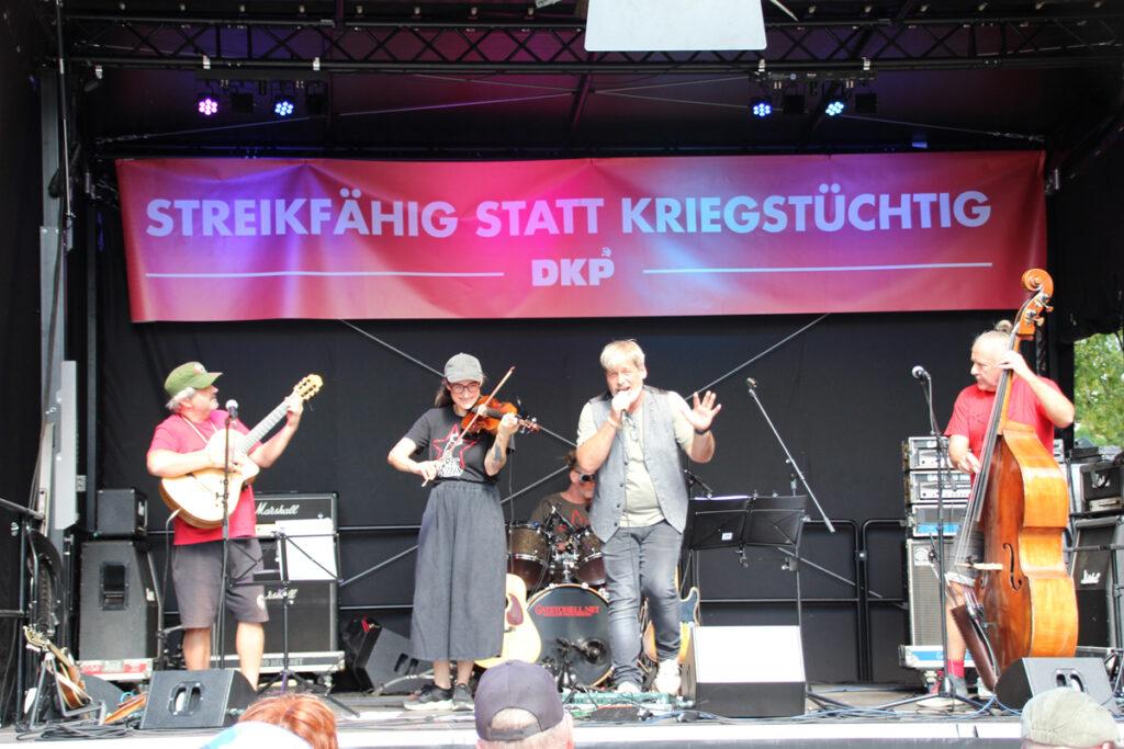 Wo sich die Klasse trifft - Achim Bigus, Banda Bassotti, Bejarano und Microphone Mafia, Betty Rossa & Kapelle, Calum Baird, Free Willy, Gina Pietsch, Grupo Resistencia, Hartmut König, Kai Degenhardt, Musik, Nicky Marquez Trio, Pablo Miró, RotFuchs-Singegruppe, Schenzer und Wilke, Tobias Thiele, Tony Àvila, Trio Quijote, UZ-Friedenstage 2026 - Hintergrund 361103 - Wo sich die Klasse trifft - Achim Bigus, Banda Bassotti, Bejarano und Microphone Mafia, Betty Rossa & Kapelle, Calum Baird, Free Willy, Gina Pietsch, Grupo Resistencia, Hartmut König, Kai Degenhardt, Musik, Nicky Marquez Trio, Pablo Miró, RotFuchs-Singegruppe, Schenzer und Wilke, Tobias Thiele, Tony Àvila, Trio Quijote, UZ-Friedenstage 2026 - Hintergrund